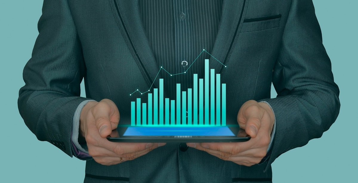 A person in a suit holding a chart